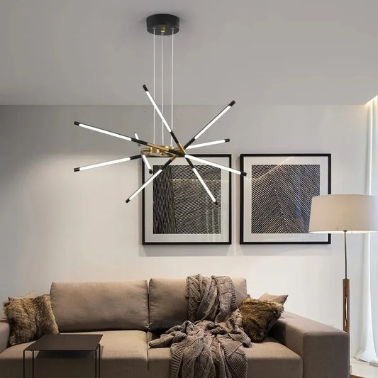 Modern chandelier hanging above a living room with a sofa and framed artwork on the wall.